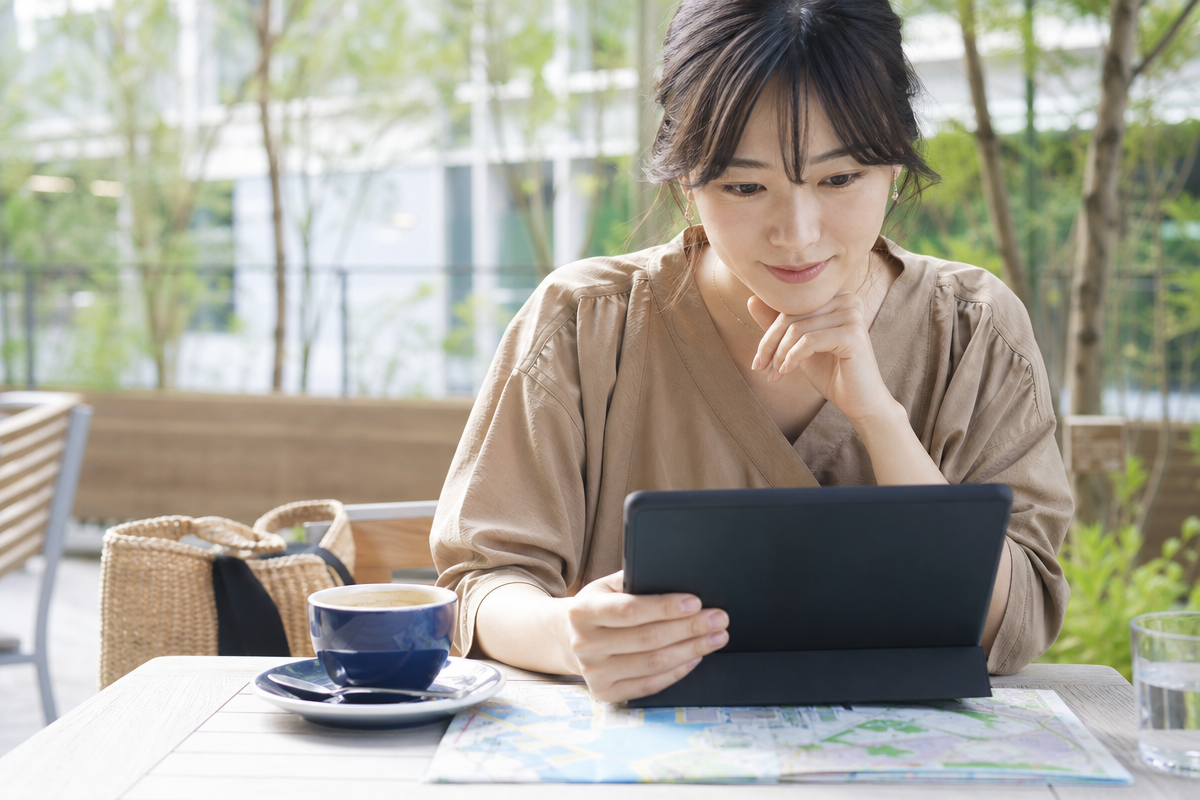 横浜の地図を見ながら酸素カプセル店舗を比較する日本人女性がタブレットで料金一覧を確認している様子